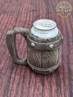 a wooden table with a metal can holder on it's side and a logo over the top