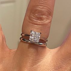 a woman's hand with a ring on it and a diamond in the middle