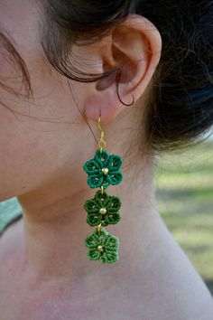 a close up of a person wearing some kind of earring with flowers on it