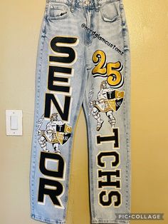 BUYER MUST PROVIDE THEIR OWN JEANS All artwork is hand painted. Design includes a total of 5 images on both pants legs.  Once payment is received, you will receive shipping address. Please allow 6 weeks for completion, starting from the date your jeans have been marked delivered. If you need it sooner, please message us to confirm availability. Rush fee $100 Senior Jeans Black And Gold, College Pants Diy, Senior Pants 2025, Homecoming Pants Decorated, Senior Pants Ideas 2025, Senior Jeans Painted 2025 Ideas, Hoco Jeans Painted Ideas, Senior Jeans Painted 2025, Homecoming Jeans Decorated