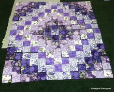 a purple and white patchwork quilt is laying on the ground