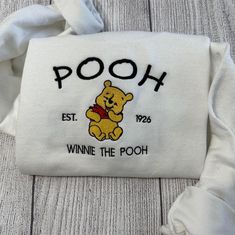 Embroidered Sweatshirts, Winnie The Pooh Embroidered Sweatshirt Gift For Herhim, Women’s Embroidered Sweatshirts – Excoolent Embroidered Sweatshirts redefine casual comfort with a touch of artistic flair. Each sweatshirt is meticulously crafted, featuring intricate embroidery that adds a unique, handcrafted touch. Made from high-quality, cozy fabric, they offer warmth and style in one. The embroidery not... Christmas Winnie The Pooh, Embroidery Crewneck, Cute Winnie The Pooh, Trendy Street Style, Embroidered Sweatshirt, Embroidered Sweatshirts, Custom Embroidery, Text Design, Casual Elegance