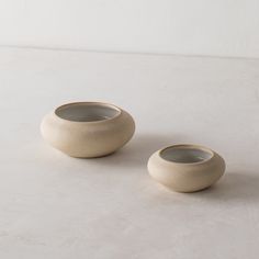 two white bowls sitting next to each other on a table