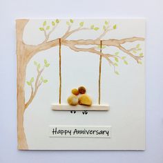 an anniversary card with two rocks on a swing