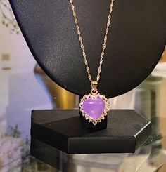 This diamond heart necklace has a centered purple stone. Gold colored. Purple is connected to the divine, the crown chakra and the third eye. Great piece to have on for great intentions. Gold And Purple Necklace, Elegant Heart-shaped Jewelry With Stones, Elegant Heart Shaped Stone Jewelry, Elegant Heart-shaped Stone Jewelry, Spiritual Purple Pendant Jewelry, Spiritual Purple Pendant Necklace, Purple Heart-shaped Amethyst Necklaces, Purple Amethyst Heart Necklaces, Purple Amethyst Heart Necklace