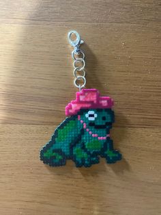 a keychain made to look like an animal with a pink hat on it