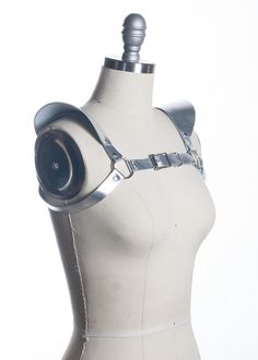 This chestpiece shoulder harness adds drama and impact to any outfit. Epaulette shoulder "wing" details. Show them you mean business! This piece works especially well with dresses and flowing tops that don't have a defined waistline. Silver toned nickel-plated steel hardware. Shown in silver metallic leather (silver leather is now lined and stitched!). Also available in black leather, black vegan leather, and PVC.Buckles in front across chest. All pieces are MADE TO ORDER, standard sizes XS-4XL. Spiked Shoulder Pads, Shoulder Pauldron Pattern, Gothic Party Harness With Straps, Elegant Fitted Black Harness, Fitted Strapped Harness For Party, Elegant Black Party Harness, Adjustable Strapped Harness For Cosplay, Gothic Fitted Harness For Party, Punk Strapped Harness For Cosplay