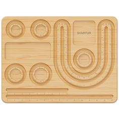 a wooden cutting board with various shapes and sizes on the front, along with a ruler