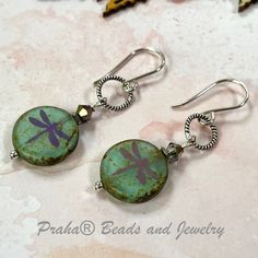 two earrings with dragonfly charms on them