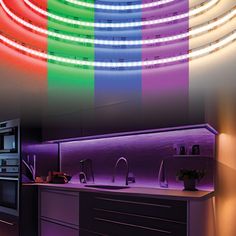 a kitchen with multicolored lights on the wall and counter top next to it