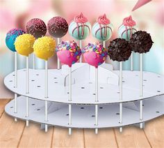 there are many different colored cake pops on the stand