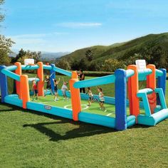 an inflatable soccer game set up on the grass with people playing around it