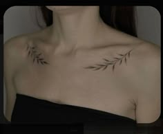 a woman's chest with two small leaves tattooed on her upper arm and shoulder