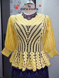 a yellow crocheted sweater on top of a mannequin