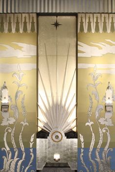 an art deco style room with decorative wallpaper and lamps on either side of the door