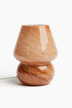 a wooden table lamp sitting on top of a white surface