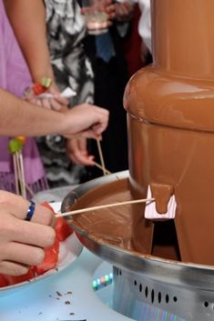 two people are making chocolate at a party