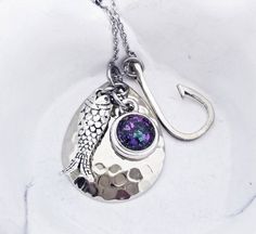 This beautiful necklace is made using your beloved pet's actual ashes (pictured in the small round stone). You may be able to see the ashes, but I have added a touch of glitter to highlight the piece. Please leave a note if you would like the ashes to be visible in your piece. The cremation pendant is approximately 1/2" and graces a dainty stainless steel link chain.  The hammered spinner blade measures 1.25". The fish hook and fish charm arevalso included with the necklace.  The stainless steel Nickel-free Charm Necklaces For Keepsake, Penny Necklace, Angel Wings Jewelry, Ashes Necklace, Cremation Necklaces, Pet Memorial Jewelry, Pet Cremation, Pet Ashes, Memorial Necklace