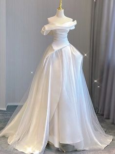 Taking inspiration from old Hollywood glamour, this beautiful A-line wedding dress is a true showstopper. The off-the-shoulder neckline and delicate pleats add a touch of elegance and sophistication to the dress, while the soft tulle fabric creates a dreamy and ethereal feel. White Off The Shoulder Wedding Dress, White Cotillion Dresses, White Ballgown Dress, Wedding Venues Church, Winter Wedding Venues, Off The Shoulder Wedding Dress, Tulle Wedding Dresses, Wedding Dress Gown, White Ball Gowns