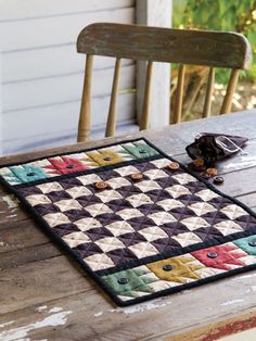 a table with a quilted placemat on top of it next to a wooden chair