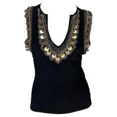 Presenting a fabulous black brass embroidered Versace sleeveless top, designed by Donatella Versace. From the Spring/Summer 2004 collection, this top features a deep v-neckline and is made complete with brassy embroidery, beads, and discs around the collar and arm holes. Add this elevated top to your wardrobe! Approximate measurements: Size - IT42/US8 22" shoulder to hem 36" - 42" bust 27" - 35" waist 9.5" shoulder to neckline plunge 83% rayon, 17% spandex Versace Top, 00s Style, Embroidery Beads, Sleeveless Top Designs, Cute Lazy Outfits, Embroidery Top, Donatella Versace, Lazy Outfits, Sleeveless Shirt