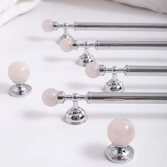 six chrome and pink glass knobs are on the bed