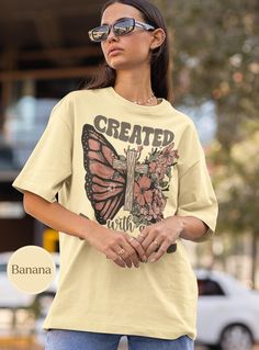 Elevate your wardrobe with our "Created with a Purpose" graphic T-shirt! Featuring a beautifully detailed design of a butterfly wing intertwined with a rustic wooden cross and blooming flowers, this shirt is not just stylish but also inspiring. The text "Created with a Purpose" and "Ephesians 2:10" serves as a meaningful reminder of strength and faith. 🦋 Perfect for casual wear or as a thoughtful gift, this T-shirt combines comfort and motivation in one unique piece. Embrace your purpose and le Created With A Purpose, Inspirational Tshirts, Jesus Shirt, Jesus Shirts, A Butterfly, Comfort Colors, San Jose, Retro Fashion, Favorite Outfit