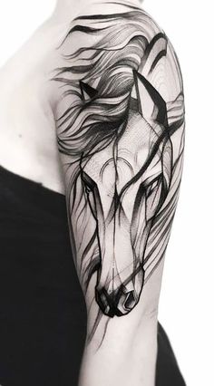 a black and white photo of a woman's arm with a horse tattoo on it