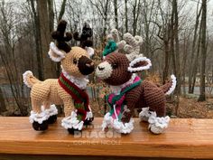 two crocheted deer figurines sitting on top of a wooden table