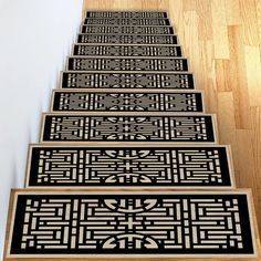 a set of four black and white stair mats sitting on top of a wooden floor