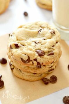 chocolate chip cookies are stacked on top of each other next to a glass of milk