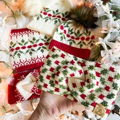 several knitted hats and mittens laying on top of a pile of christmas decorations