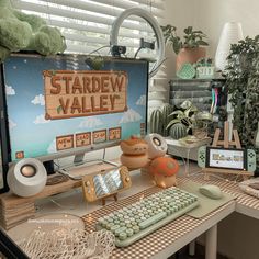 there is a computer screen and keyboard on the desk with other items in front of it