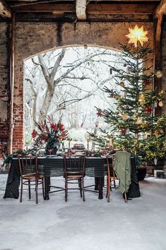 a dining room with a christmas tree in the center and decorations on the tables around it