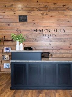 the front desk of magnolia realty with wood paneling and wooden walls behind it