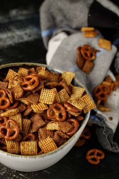 a bowl filled with cheetos and pretzels on top of a table