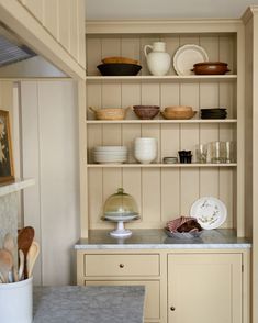 the kitchen is clean and ready to be used for cooking or baking, as well as dishes on shelves