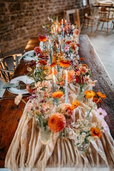 a long table with flowers and candles on it