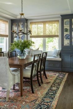 a dining room table with chairs and a rug on the floor