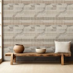 two vases on a bench in front of a wall with a pattern behind it