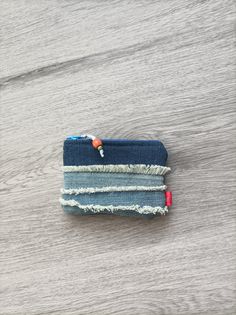 a small blue wallet sitting on top of a wooden table