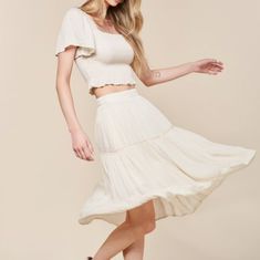 Elevate Your Summer Style With Our Woven Skirt Set In White! The Crop Top Features A Flattering Square Neckline And Smocking For A Perfect Fit, While The Flowy Sleeves And Ruffle Detail Add A Touch Of Charm. The Midi Skirt Has An Elastic Waistband And Lace Trim For A Feminine Touch, And Is Fully Lined For Comfort. Made Of 100% Rayon And 100% Polyester Lining. Model Is 5'8" And Wearing A Size Small. Fit: True To Size Pockets Skirt Lined Rayon Casual Ruffled Rayon Skirt, Off White Relaxed Skirt For Spring, Off White Relaxed Fit Skirt For Spring, Cream Maxi Skirt With Elastic Waistband For Summer, Spring Off White Relaxed Fit Skirt, White Rayon Skirt For Summer, White Rayon Summer Skirt, Off White Tiered Skirt For Spring, Spring Off-white Tiered Skirt