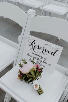 there is a sign that says reserved on the back of a chair with flowers in it