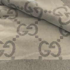 an image of a gucci logo printed on the fabric in grey and white colors