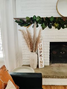 a living room with a white brick fireplace and plants in a vase on the mantel