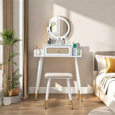 a white vanity table with a mirror and stool next to a bed in a room