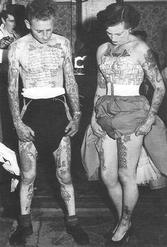 two tattooed men are walking down the street