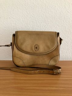 Vintage shoulder bag by Étienne Aigner made of beige leather. The bag is in very good vintage condition, only slight superficial and age-related signs of wear. The bag can be closed with a gold-colored button. Inner lining is made of leather in beige with slight discoloration. One main compartment and an additional open side compartment and a compartment with a zipper on the inside. The bag has an adjustable shoulder strap. Width 24cm Height 18cm Depth 7cm Shoulder strap up to a maximum length of 125 cm Please remember that this is a vintage item and not new! High quality. Please note my other offers. Classic Beige Bags With Brass Hardware, Beige Shoulder Bag With Brass Hardware For Travel, Beige Shoulder Bag With Brass Hardware, Vintage Beige Shoulder Bag, Vintage Beige Satchel For Travel, Vintage Cream Shoulder Bag With Adjustable Strap, Vintage Beige Satchel, Classic Beige Shoulder Bag, Vintage Light Brown Crossbody Shoulder Bag