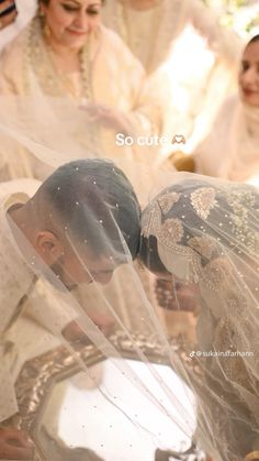 the bride and groom are getting ready for their wedding ceremony to begin, with veil blowing in the wind