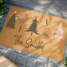 a door mat that says the smiths with tennis rackets and trees